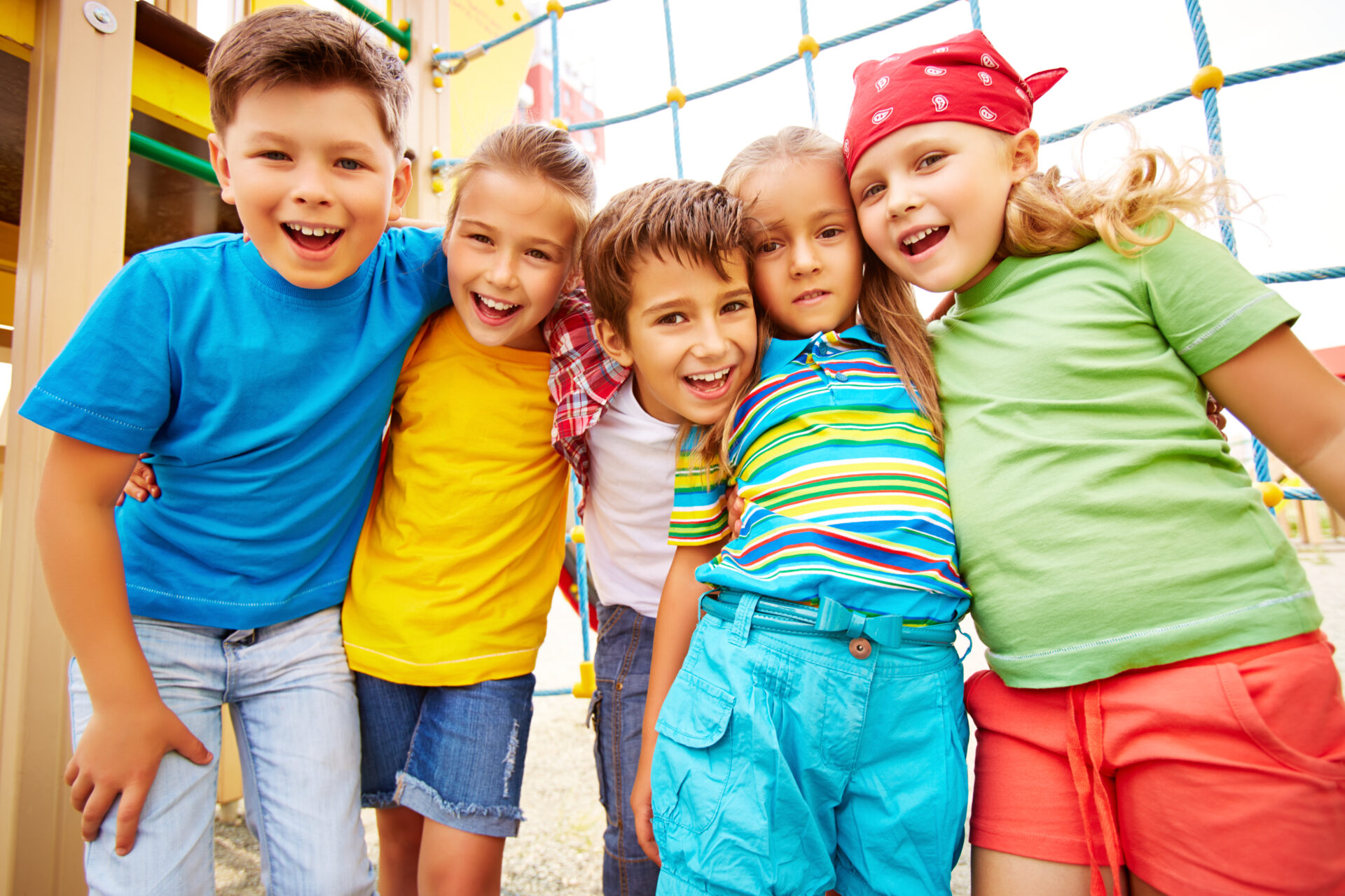 Happy friends looking at camera on playground outdoors