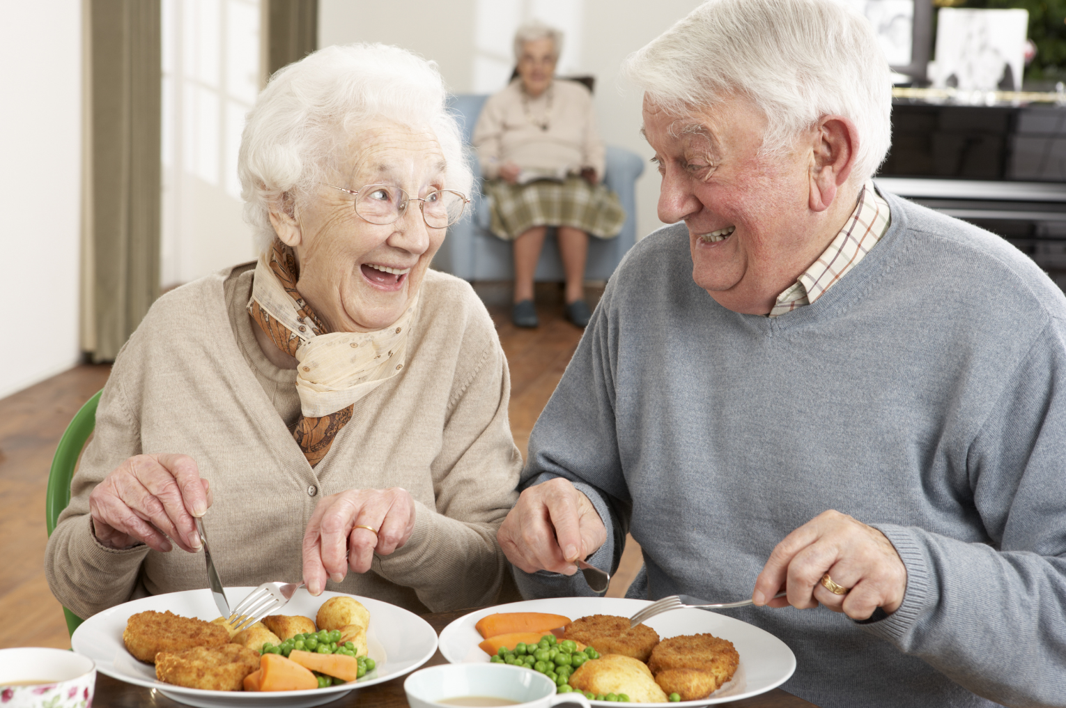 Uśmiechnięci seniorzy podczas wspólnego posiłku
